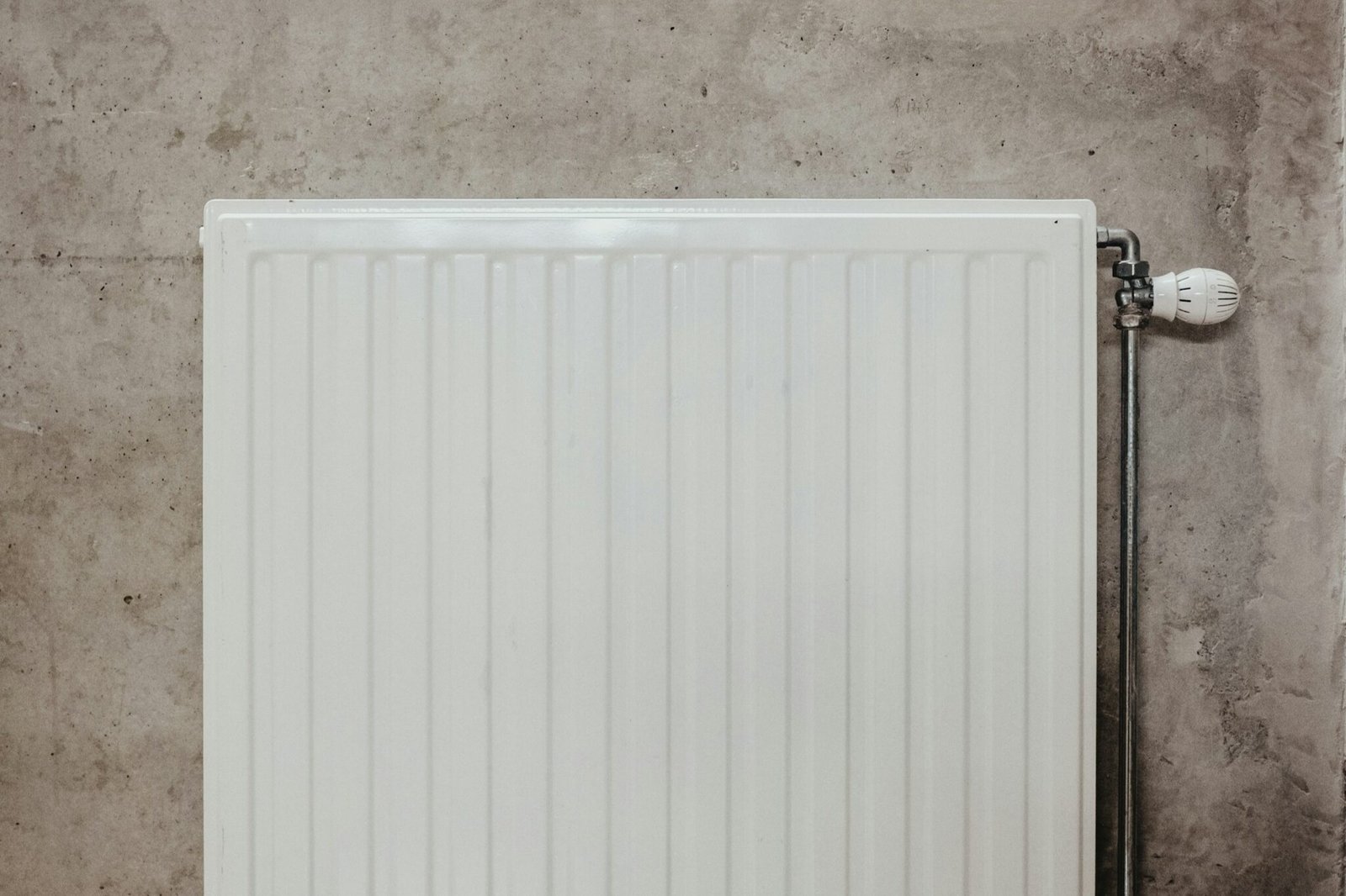 Kleiner Metallschlüssel vor einem Heizkörperventil